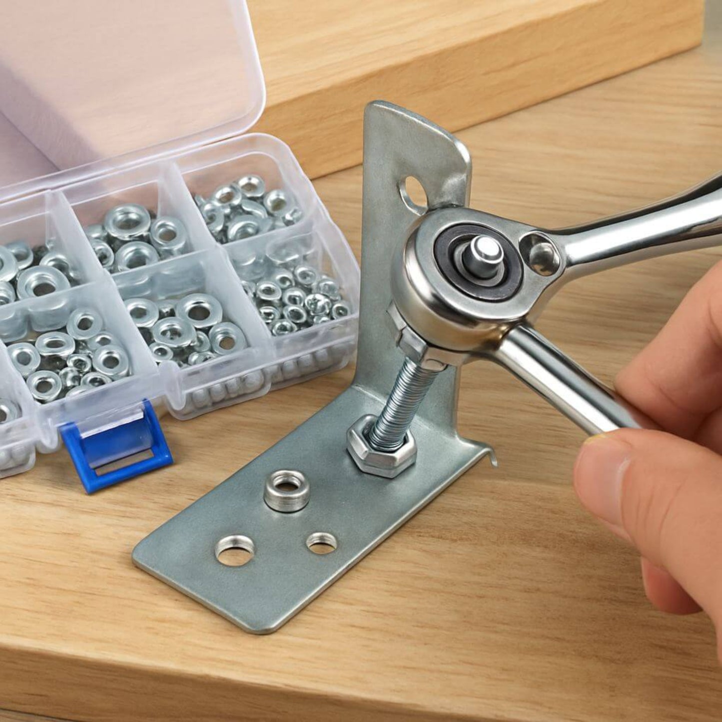 Person using a wrench on a stainless steel hex nut while installing on a metal bracket, with a box of assorted nuts beside.