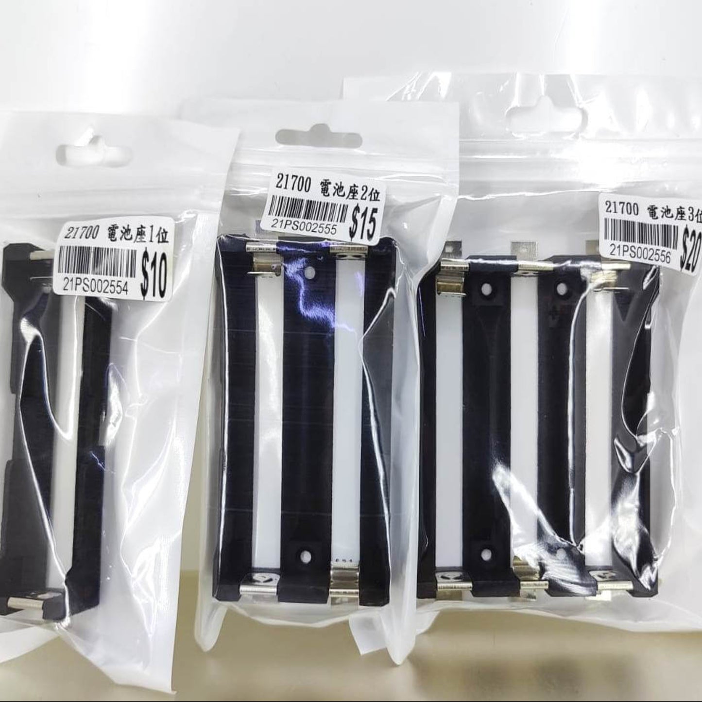 21700 battery holders in single, dual, and triple slot options, displayed in clear packaging for DIY projects.