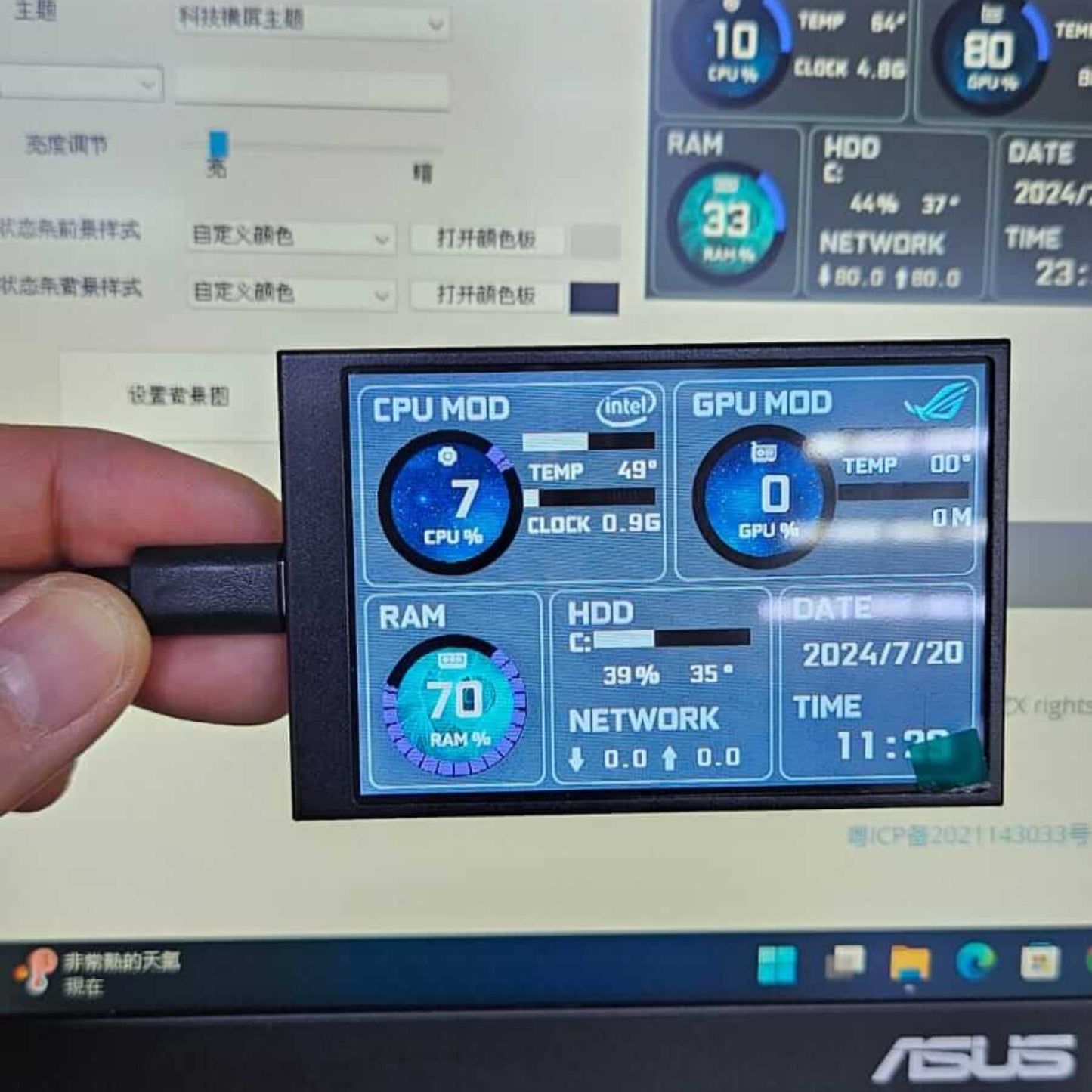 3.5-inch IPS mini monitor displaying CPU and GPU stats while being held above a laptop keyboard.