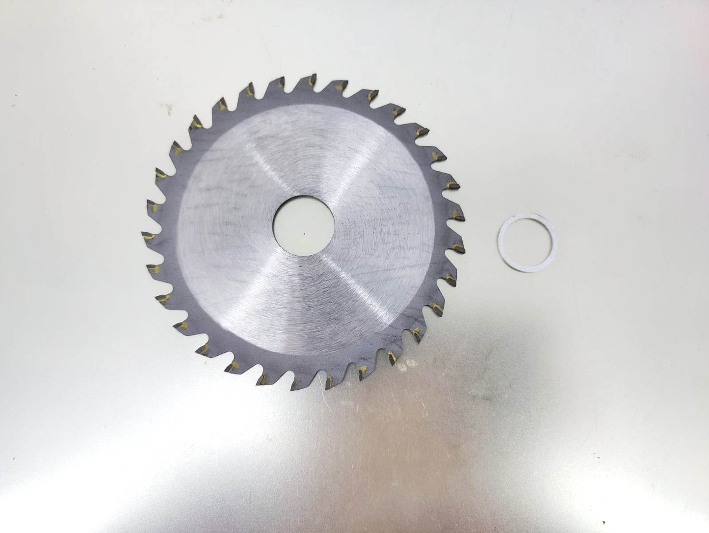 4 inch 110mm saw blade with 30 teeth for cutting hardwood, displayed on a metallic surface.