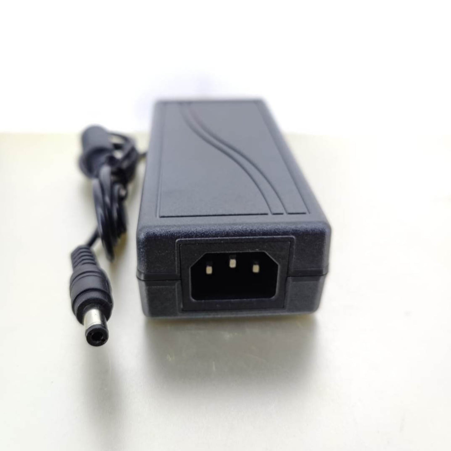 IEC 320-C14 input port and 5.5x2.1mm DC output barrel connector on 36V 2A charger.