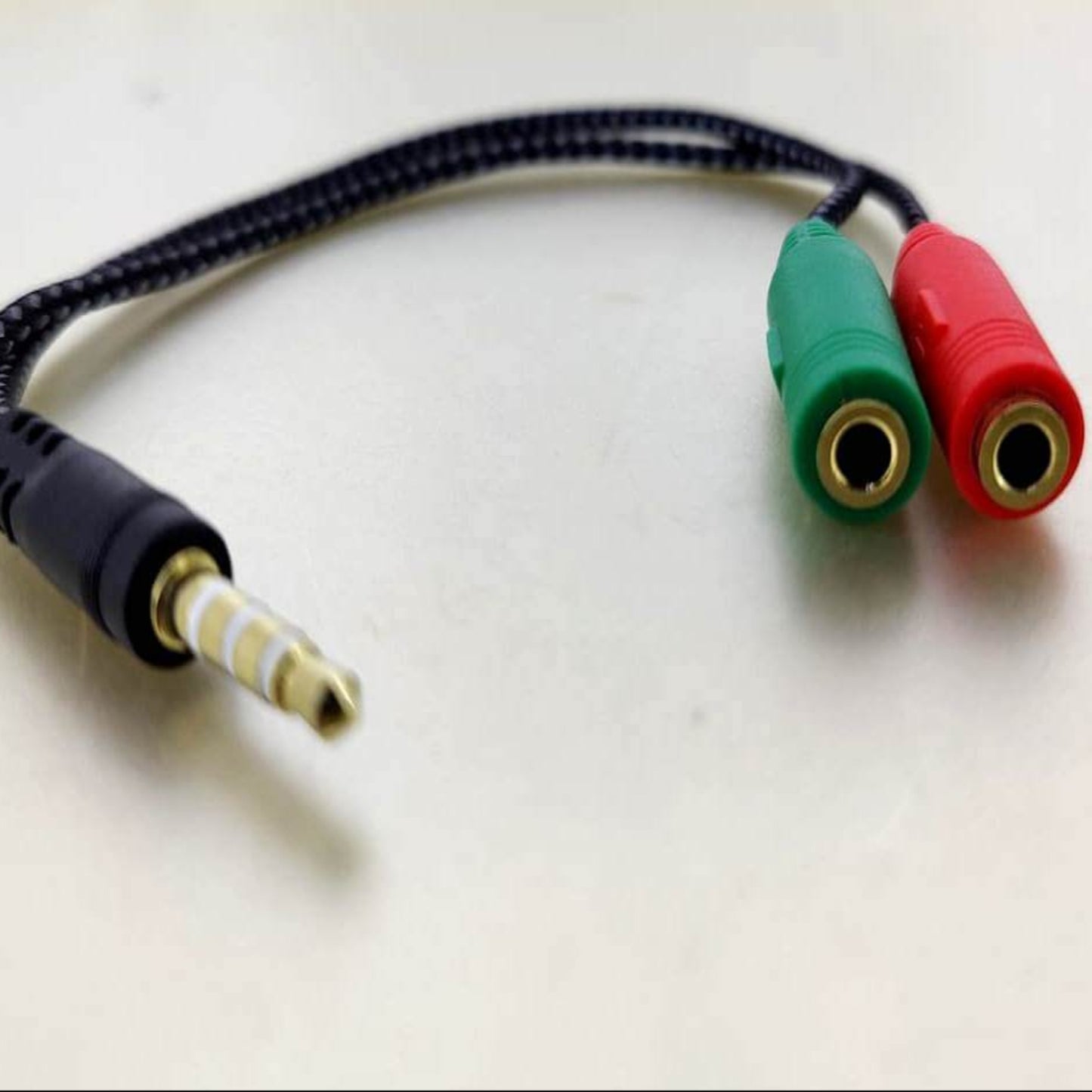 3.5mm headphone and mic splitter adapter with green and red ports for audio connection.