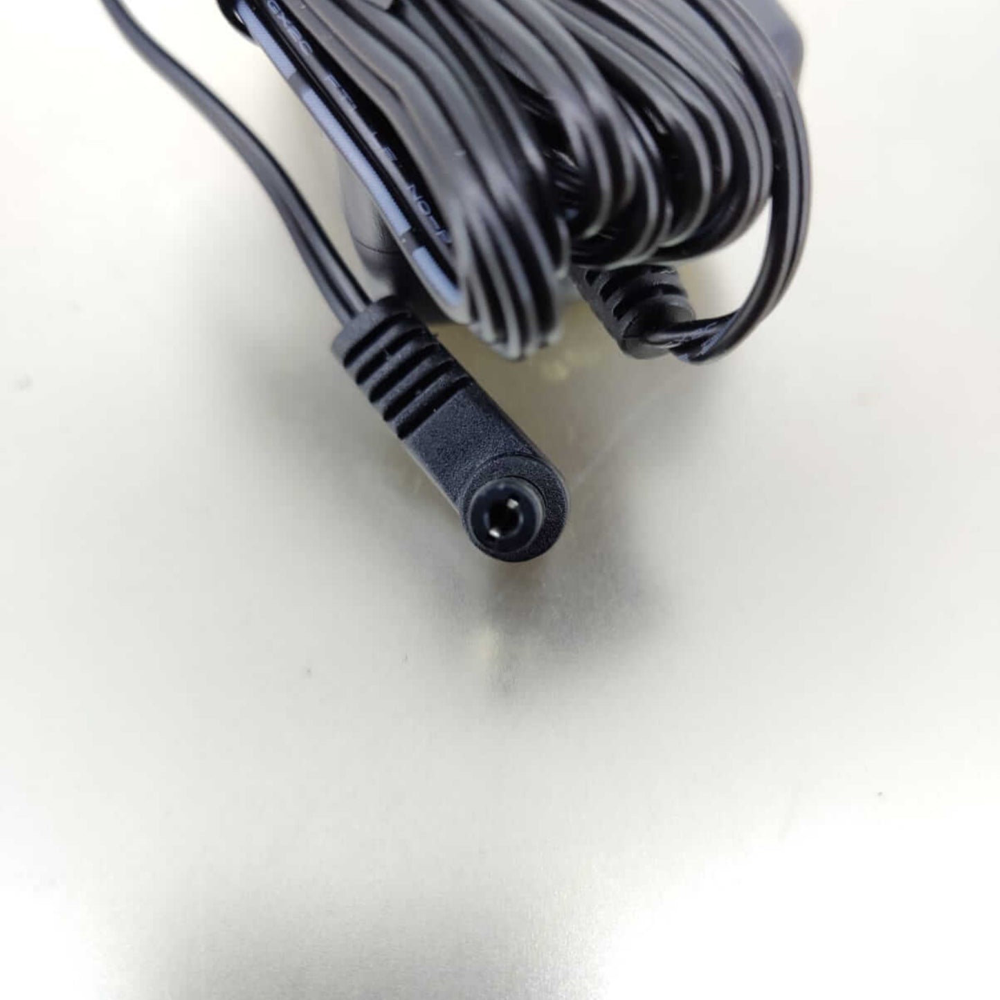 Close-up of a 5.5mm x 2.1mm DC plug connector from a 5V 2.5A universal AC/DC power adapter.