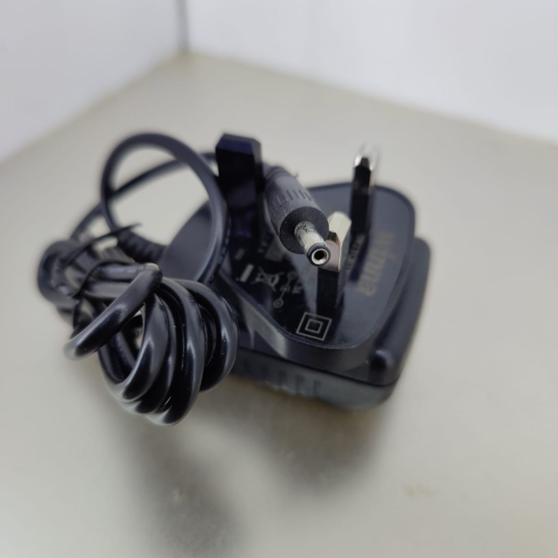 DC 5V 2A power adapter charger with a 3.5mm x 1.35mm connector and coiled cable, ideal for universal use.
