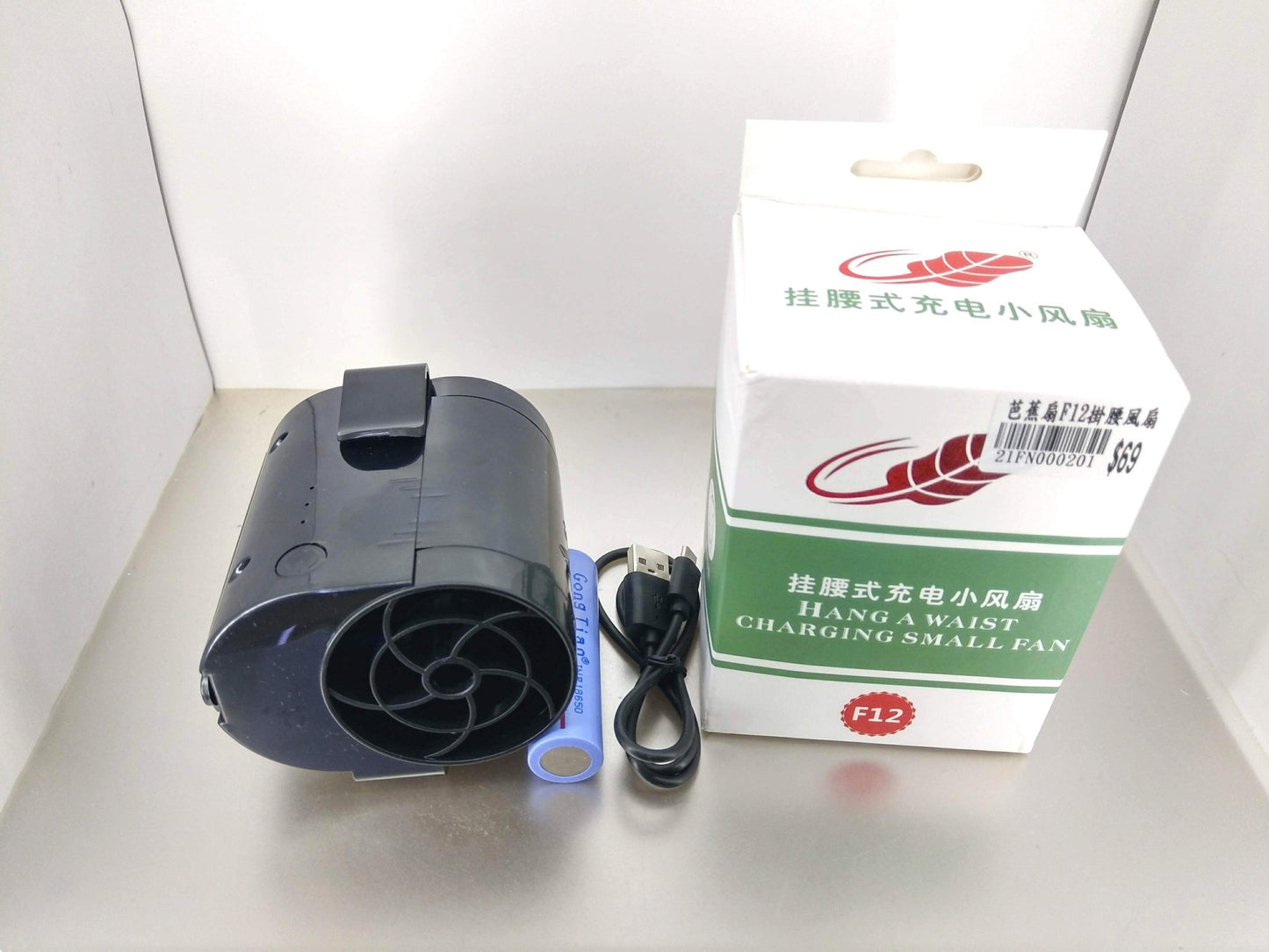 Black portable waist clip fan with packaging and accessories.