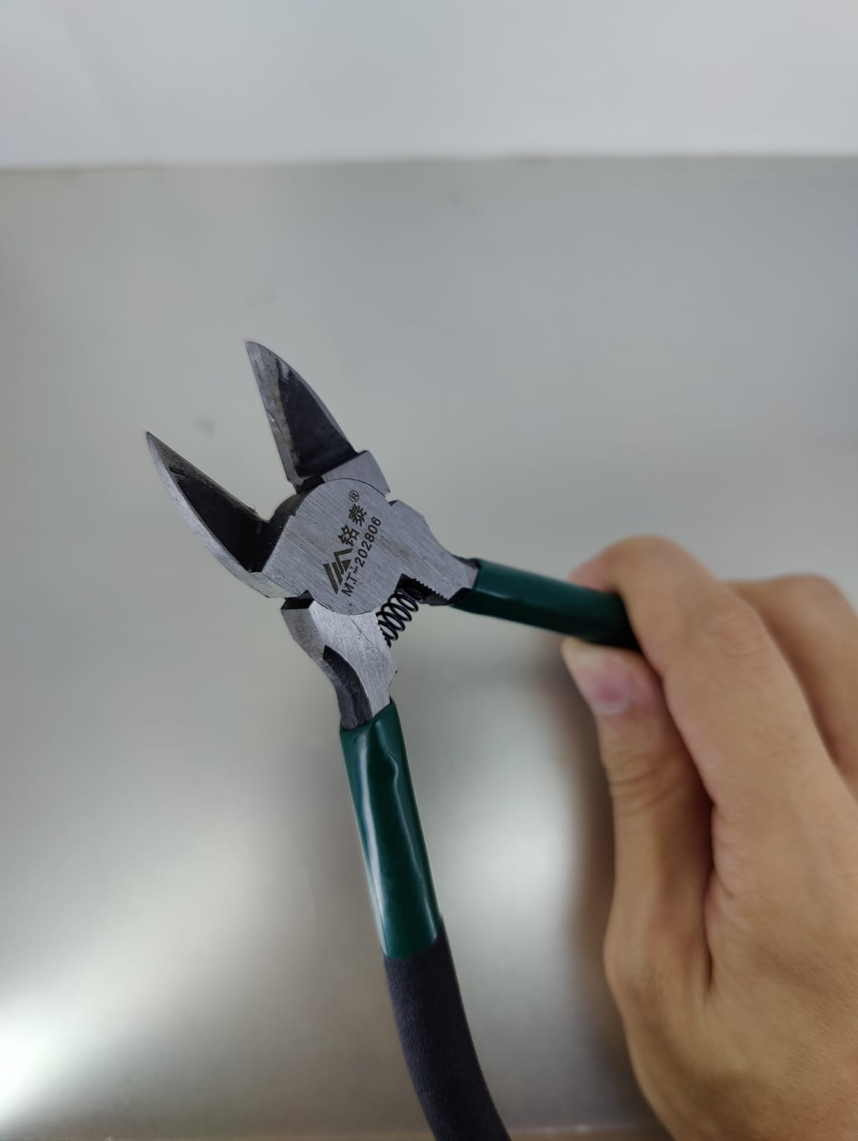 Close-up of a 6 inch cable cutter with green handles, ideal for cutting wires and cables with precision.