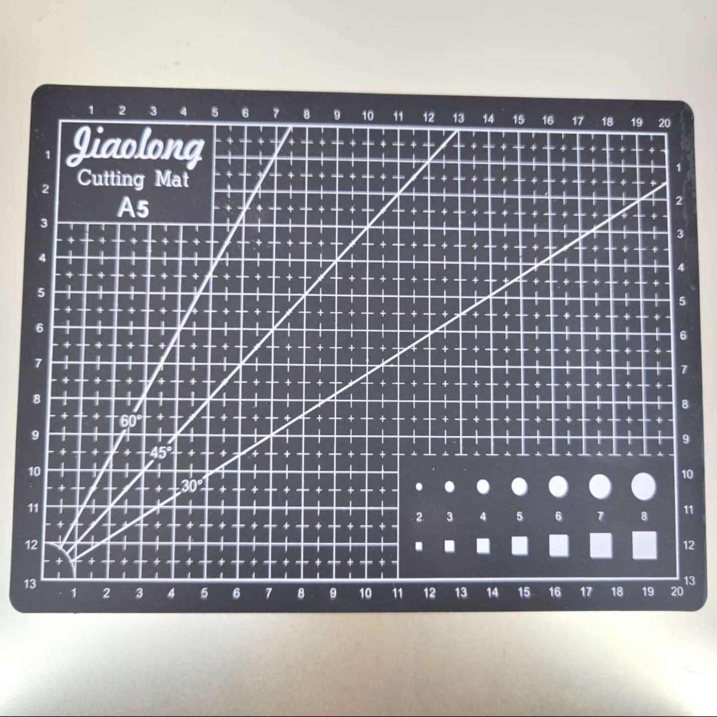 A5 cutting mat with grid lines for sewing and crafts, designed for durability and precision in fabric cutting.