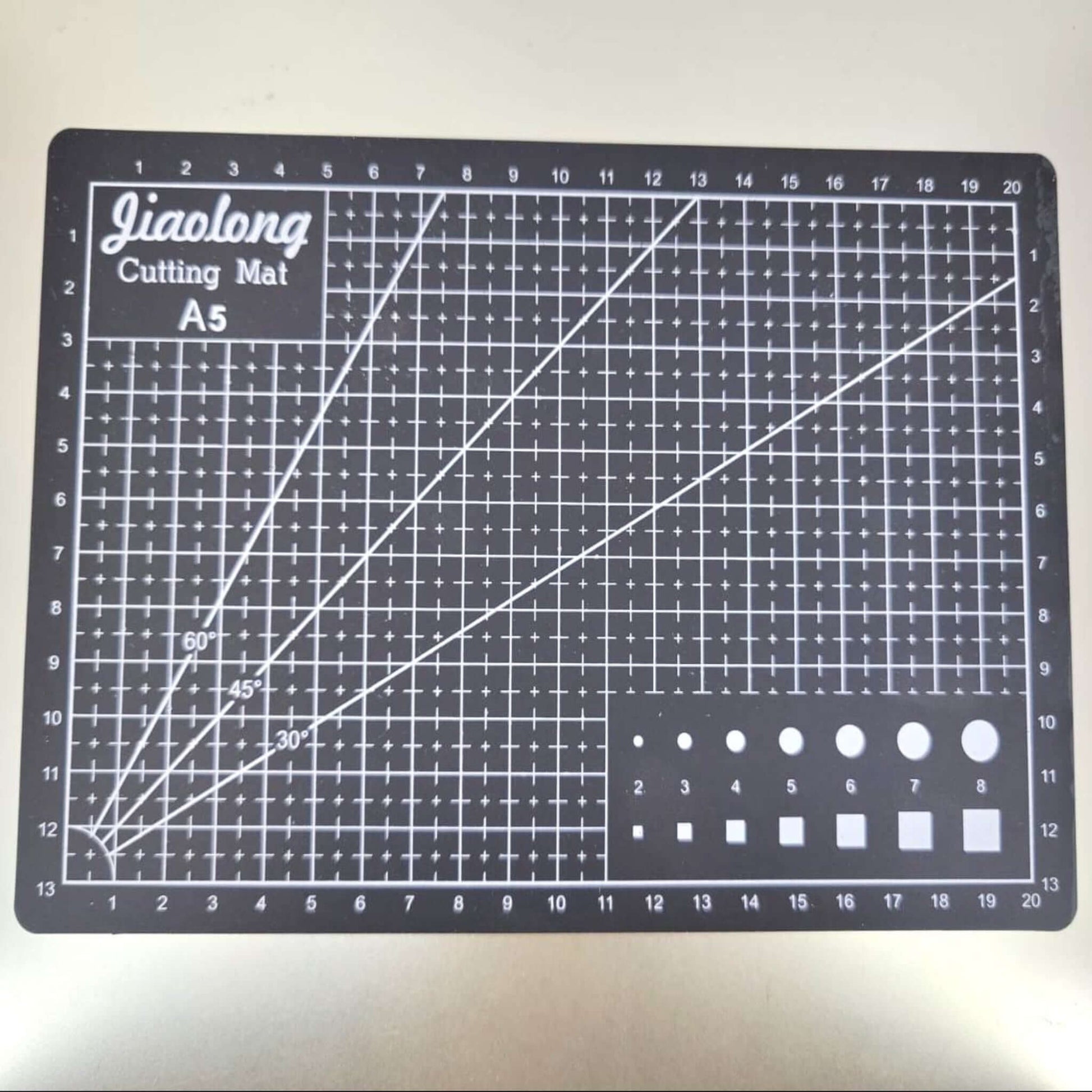 A5 cutting mat with grid lines for sewing and crafts, designed for durability and precision in fabric cutting.