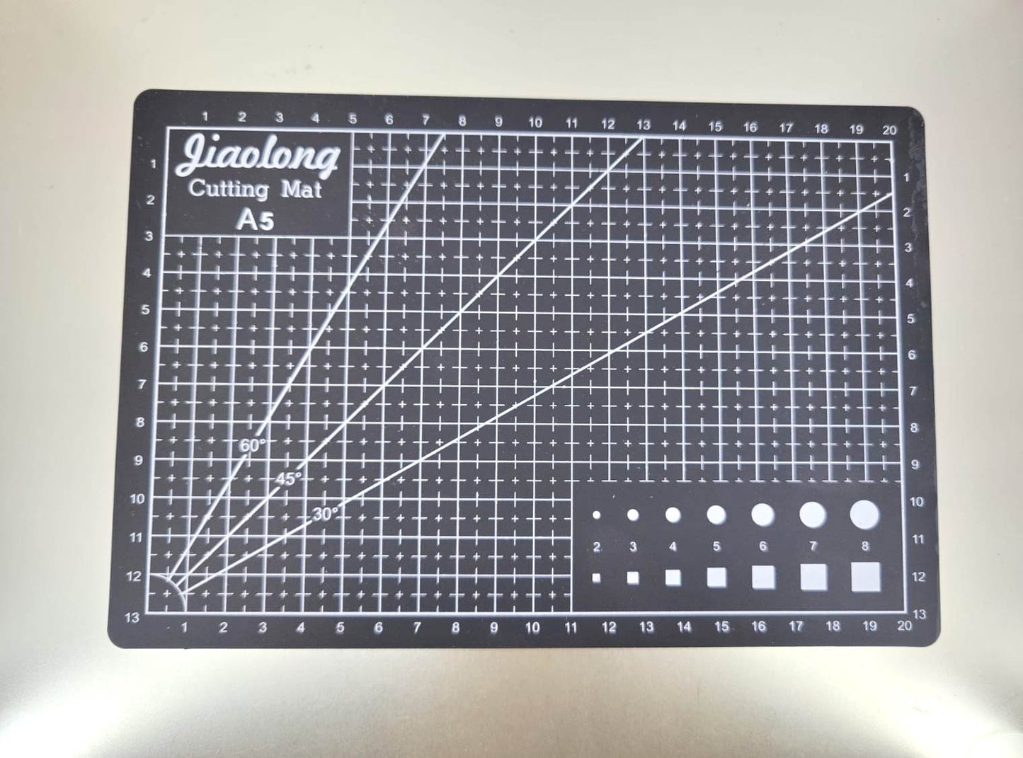 A5 cutting mat with grid lines for sewing and crafts, designed for durability and precision in fabric cutting.