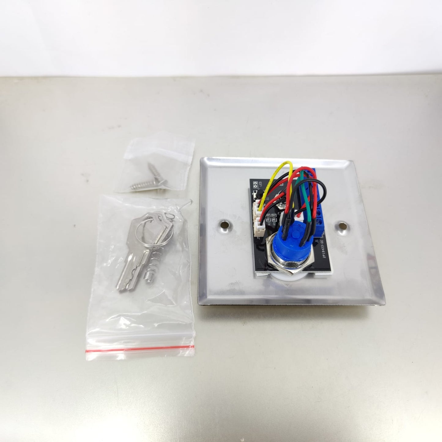 The 86-type key switch shown with its two included keys and mounting screws.