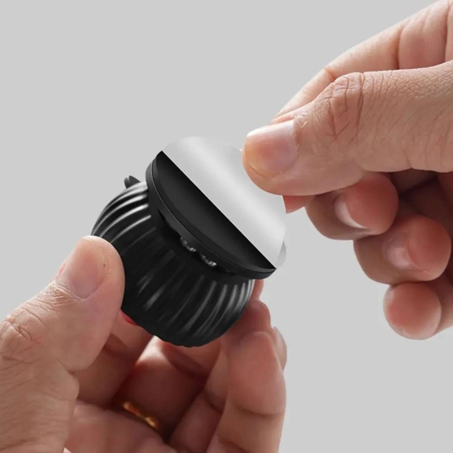 Hand demonstrating the easy self-adhesive application of a black universal wheel caster to a surface.