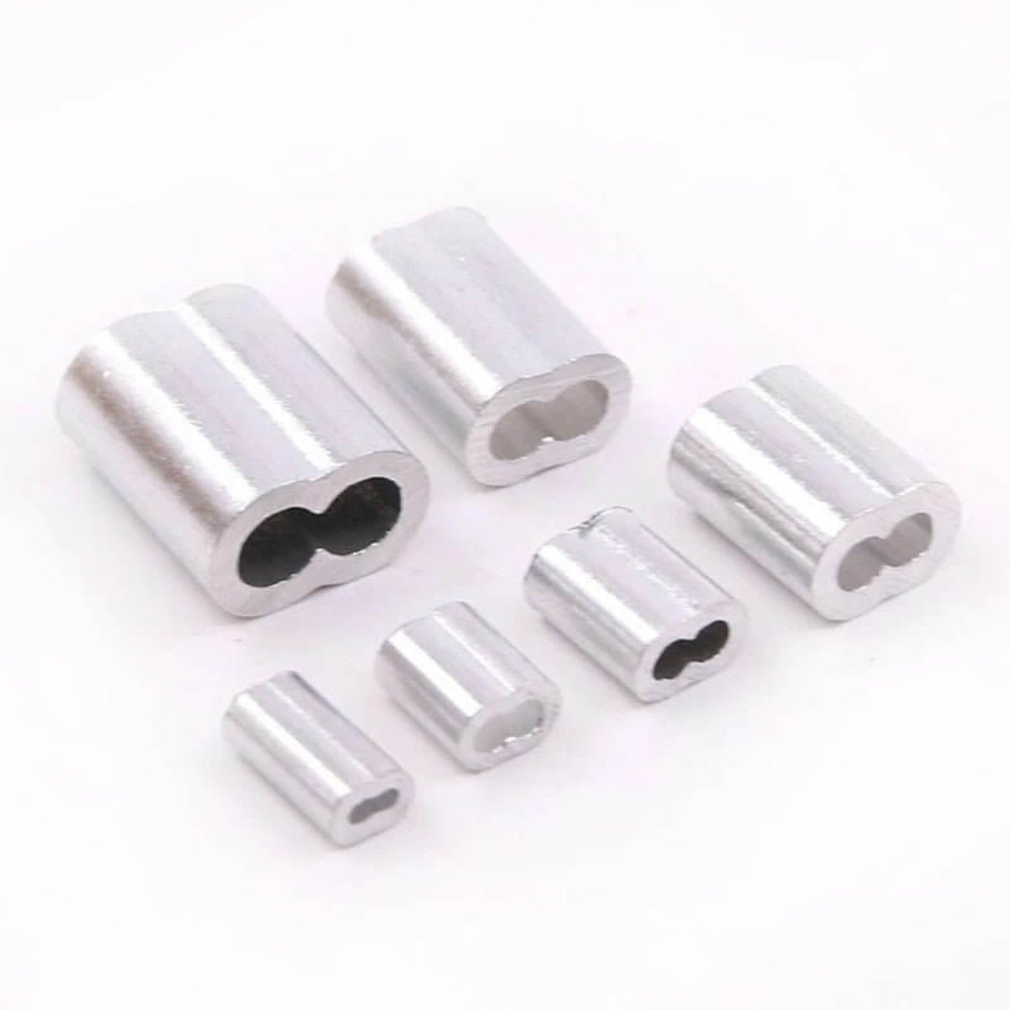 A collection of various sizes of aluminum double barrel ferrules for wire rope.