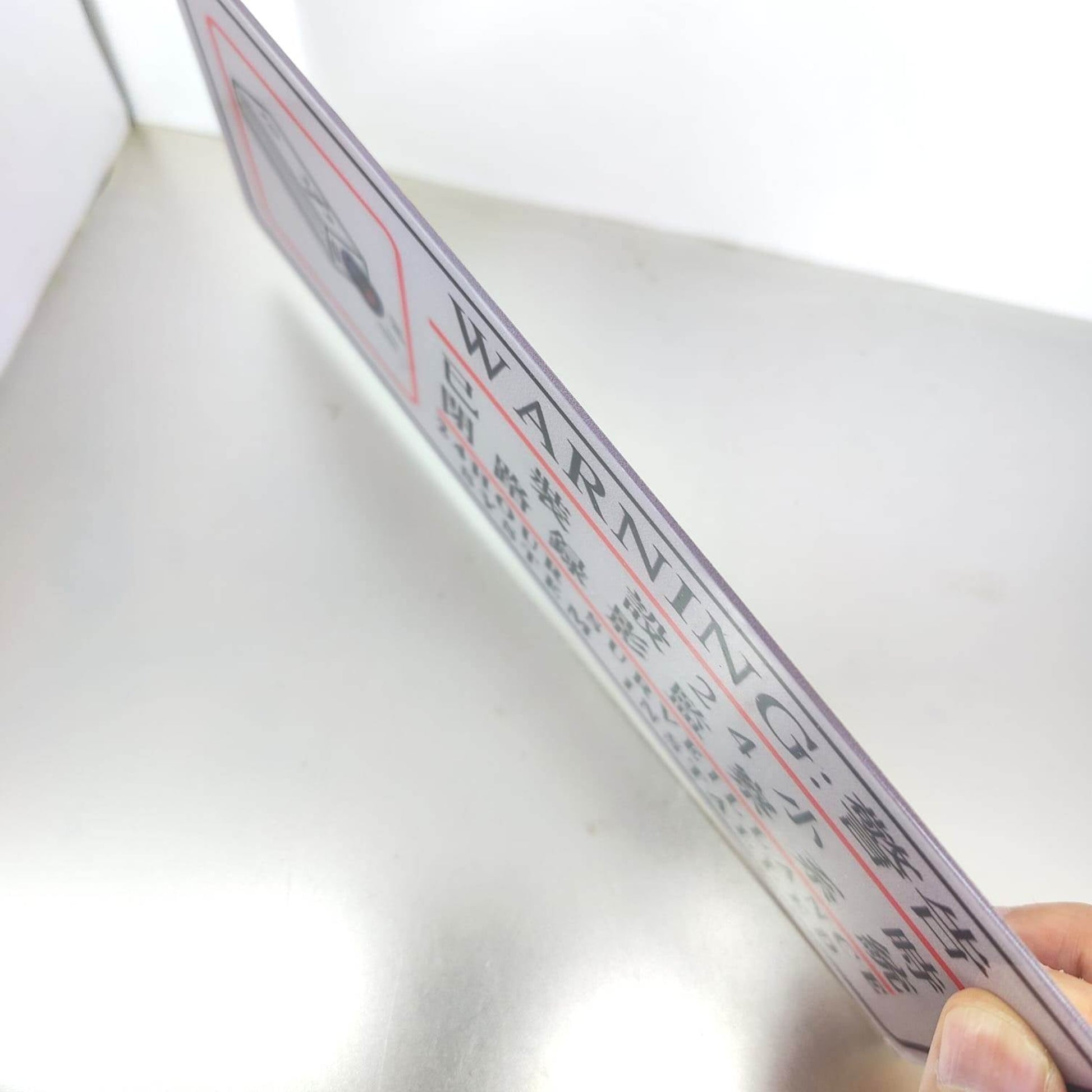 Angled side view of the self-adhesive CCTV 24 hour surveillance sign, highlighting its thin profile.