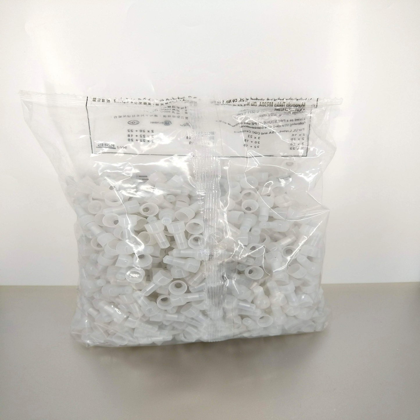 A large bag of 1000 pieces of white CE-2X closed-end wire connectors, showing the product in its bulk packaging.