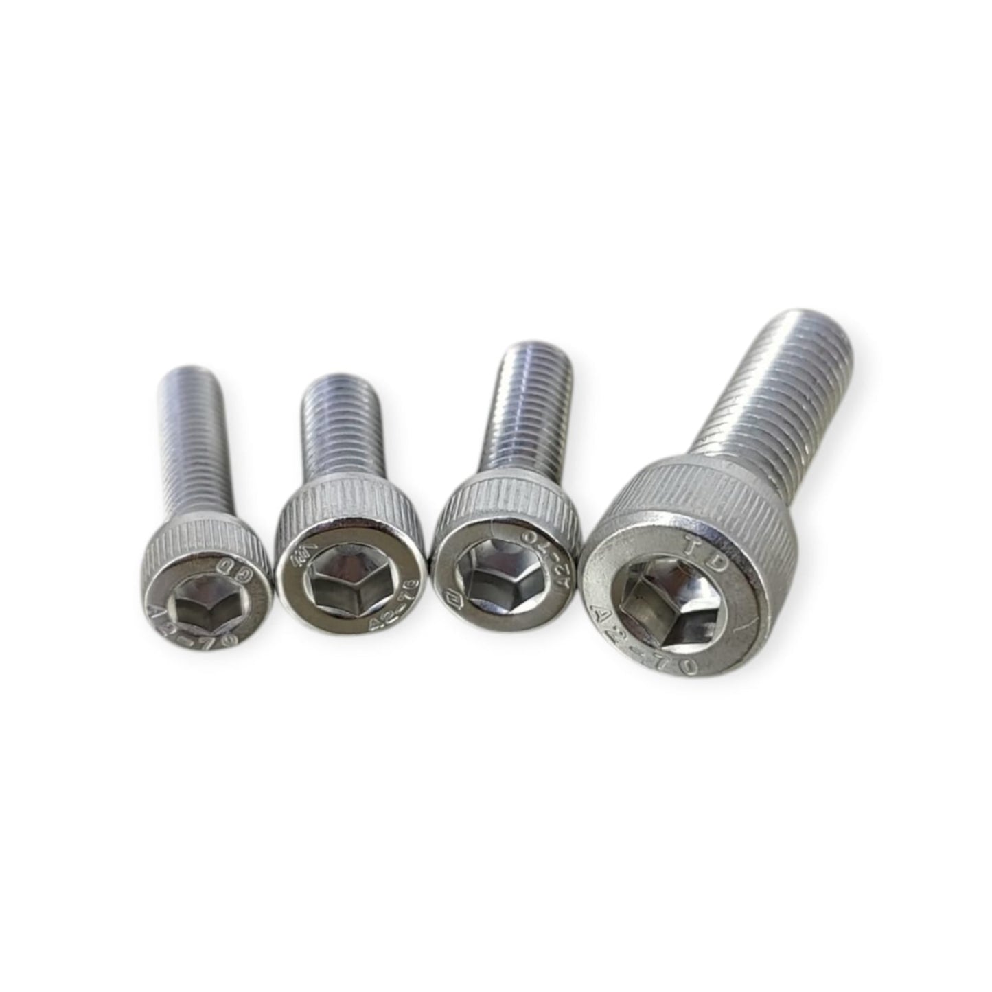 A close-up of four different sizes of M-series socket cap screws made from A2-70 stainless steel, showing the hex socket head.