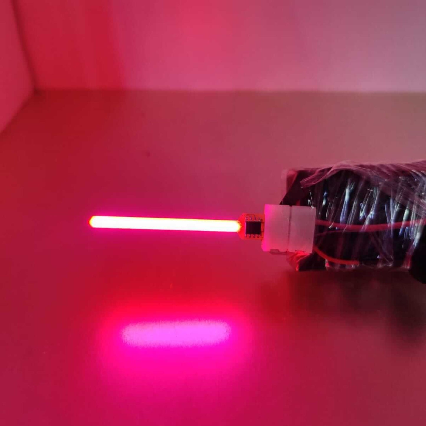 Close-up of a glowing red LED lamp filament emitting vibrant light, showcasing modern lighting design.