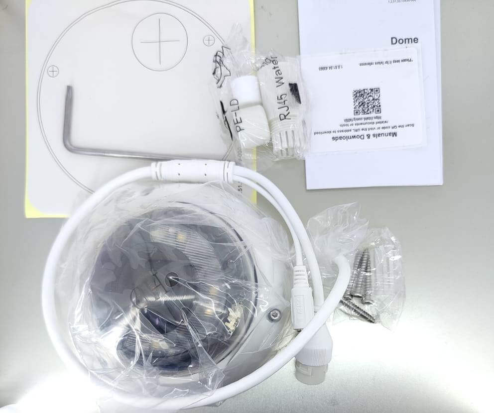 Dahua 4MP Smart Dual Light Dome Camera kit components including lens, cables, manual, and installation tools.