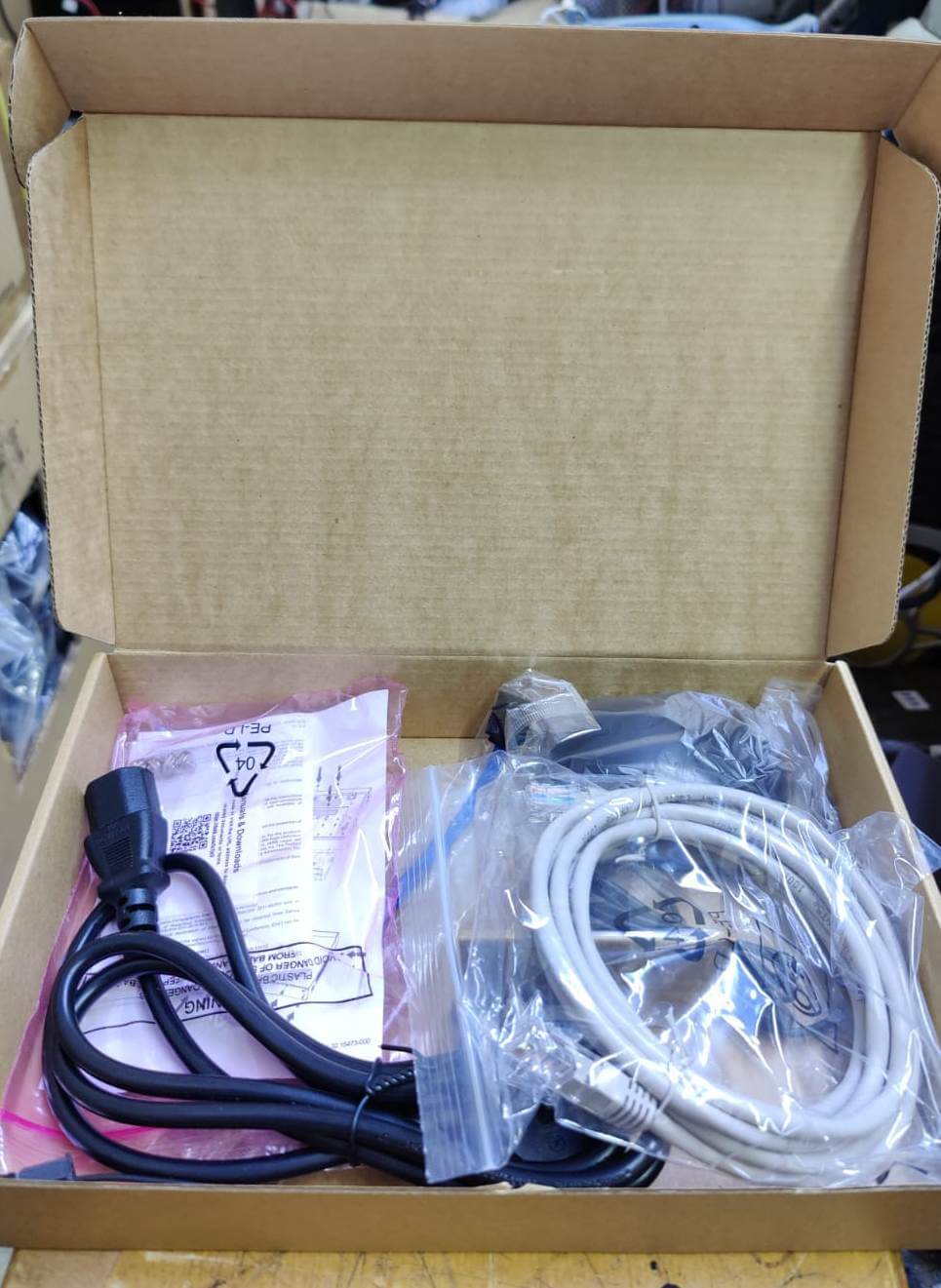 Open box containing cables and connectors for network video recorder installation.