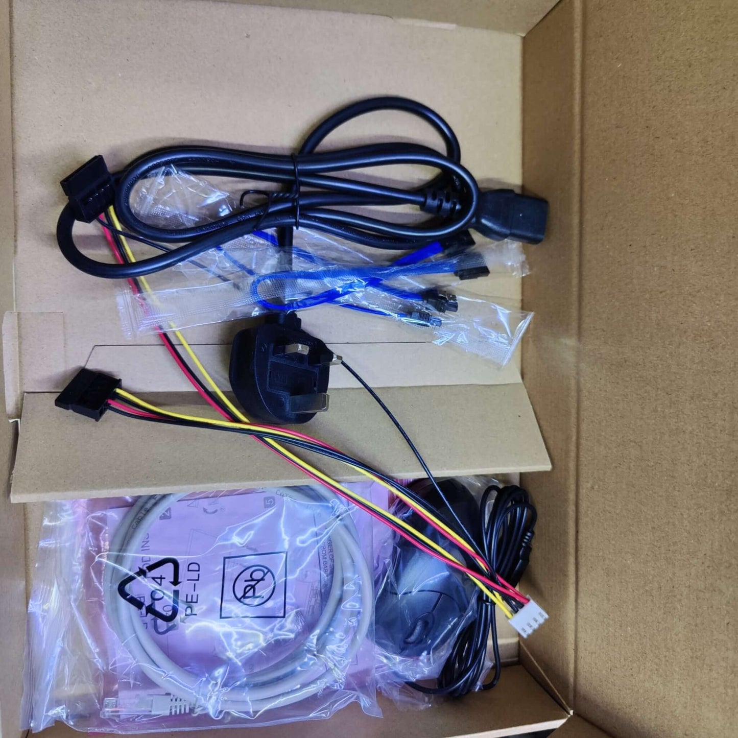 Contents of Dahua NVR4208-8P-EI box: cables, power adapter, mouse, and other accessories.