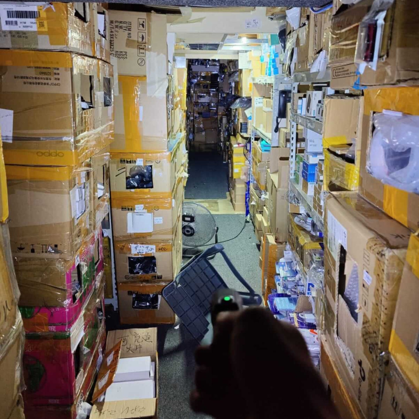 High Power Compact Flashlight - 15W Strong Beam, Rechargeable illuminating a dimly lit corridor filled with boxes.