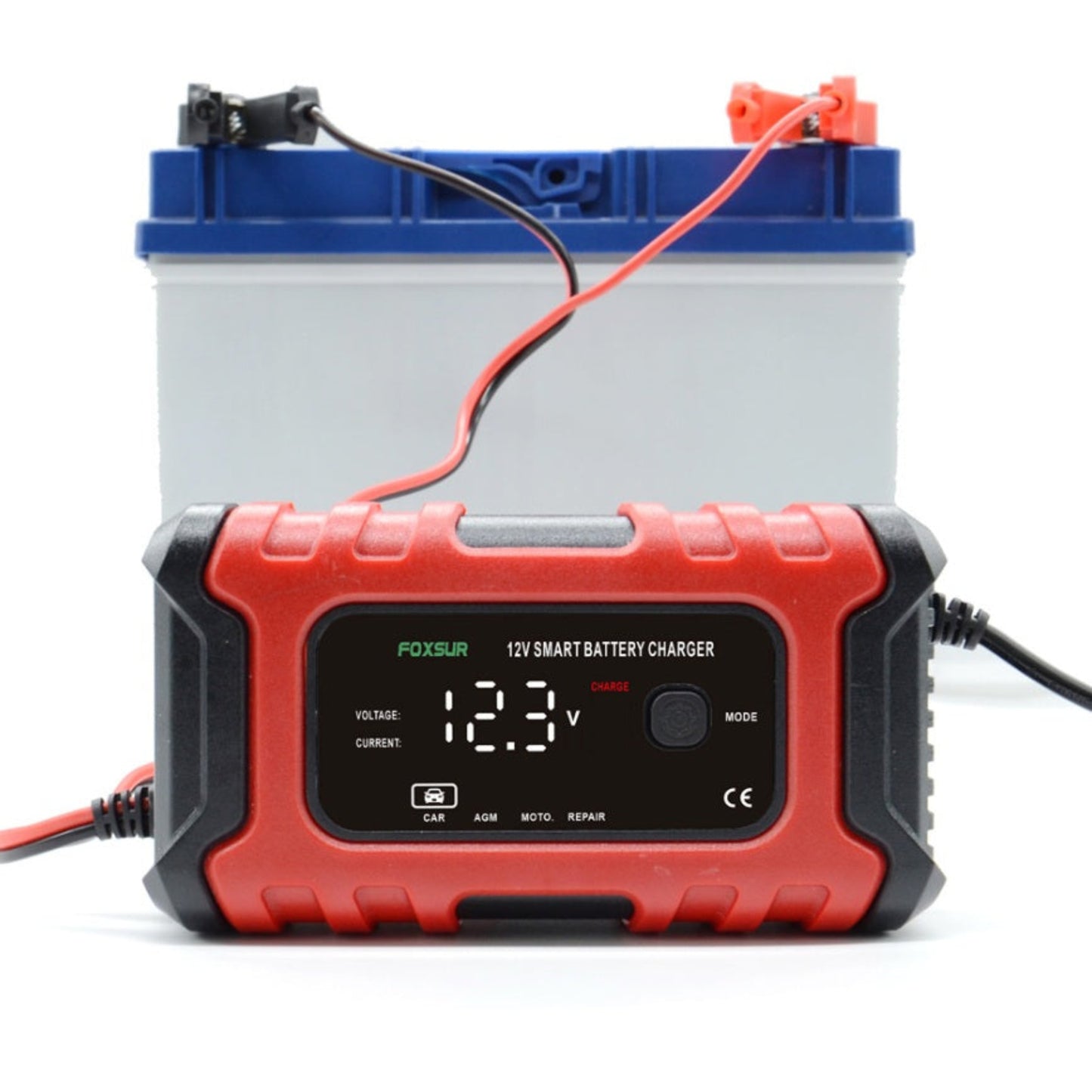 FOXSUR 12V 6A Smart Battery Charger in front of a car battery, displaying charging voltage and current.
