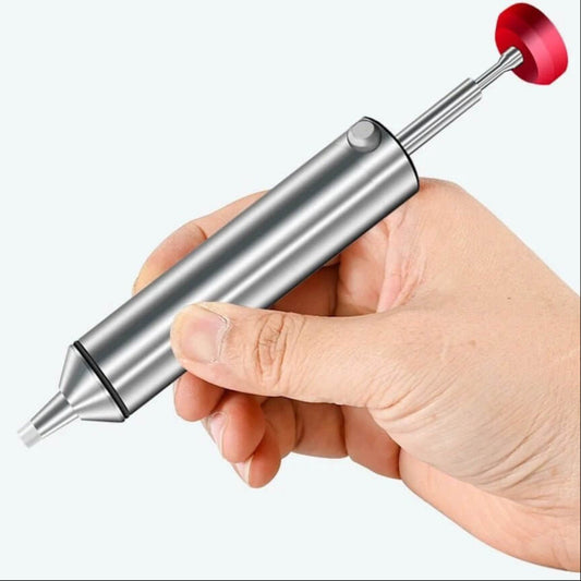 A hand holding the compact aluminum desoldering pump to show its ergonomic size for one-handed use.