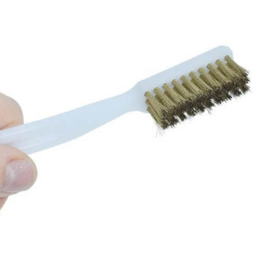 A hand holding the mini wire brush, demonstrating its size and ergonomic design for easy grip.