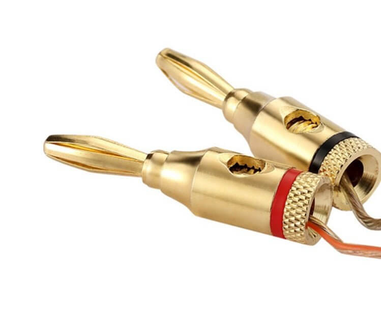 Close-up of gold-plated solderless speaker banana plugs showcasing secure audio connections.