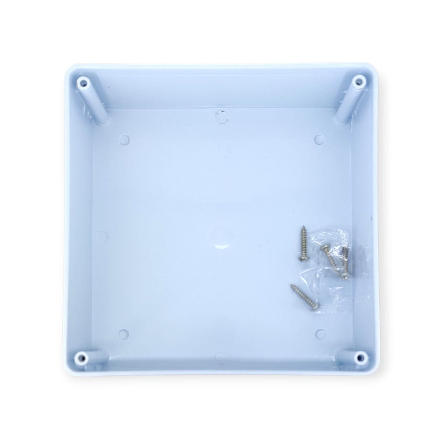 Inside view of the waterproof junction box base, showing internal mounting posts and a packet of screws.