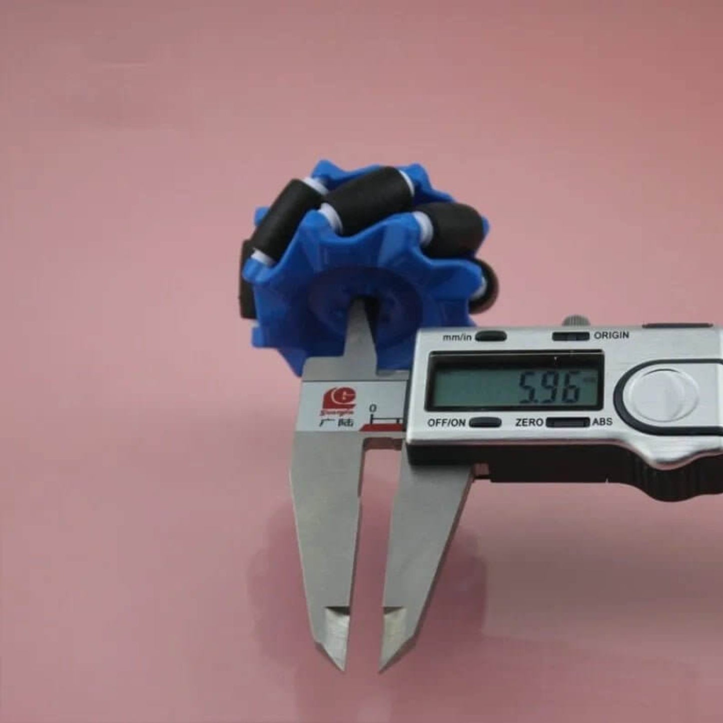 Blue 52mm Mecanum wheel center bore measured at 5.96mm with digital calipers.