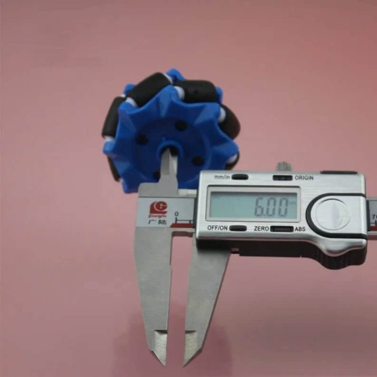 Blue 52mm Mecanum wheel's center hole measured at 6.00mm with digital calipers.