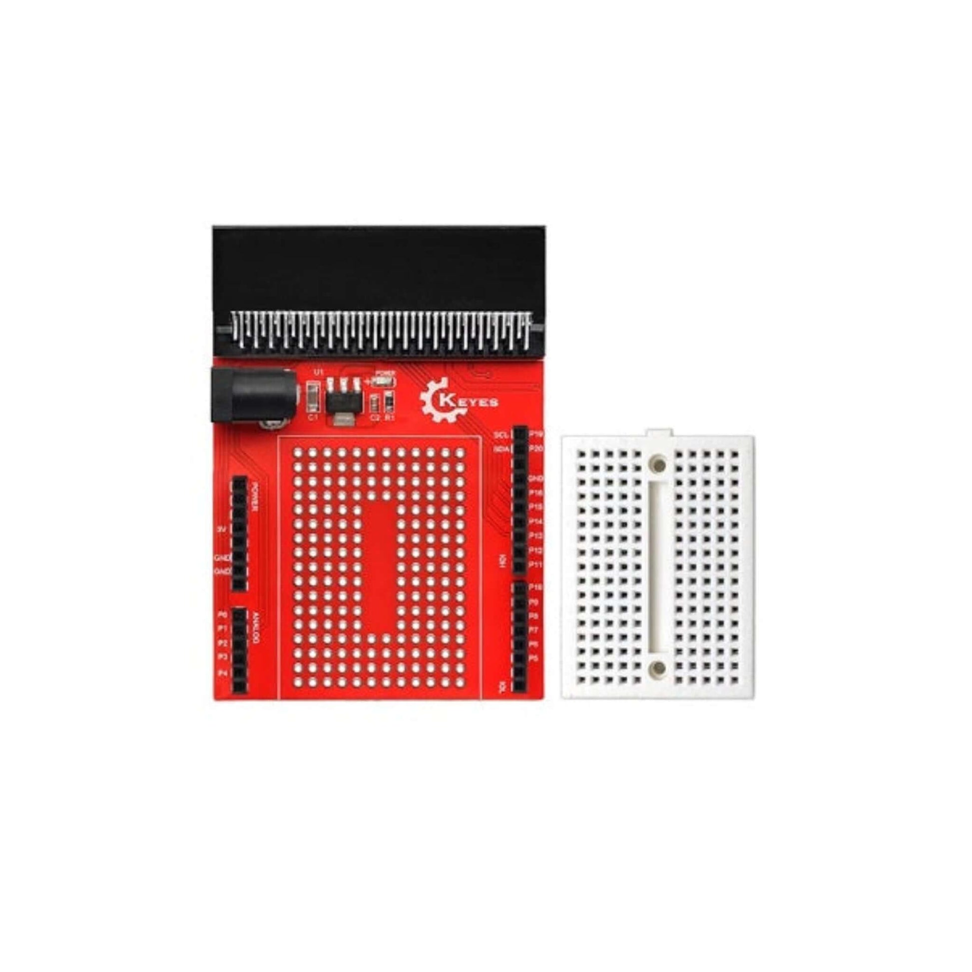 Top-down view of the red micro:bit IO expansion board next to its separate 170-point white mini breadboard.