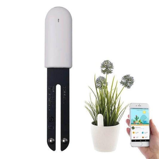 White and black smart plant monitor next to a potted plant, with a smartphone displaying the plant care app interface.