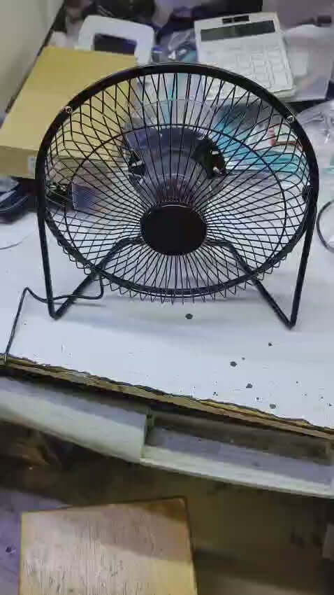8-inch USB desk fan with black wireframe design on a workspace table for portable and quiet cooling.