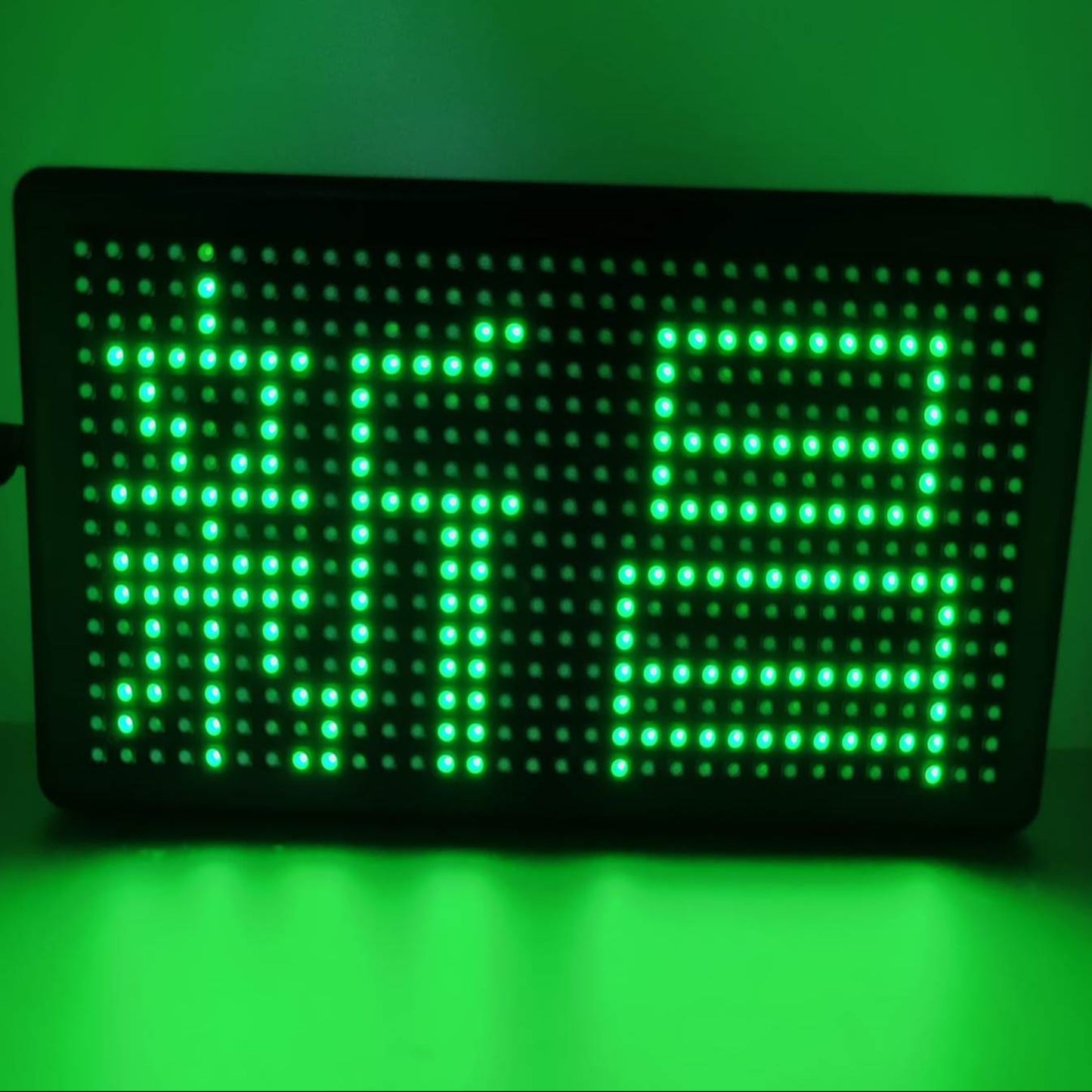 Green LED scrolling sign board displaying custom messages in bright lights.