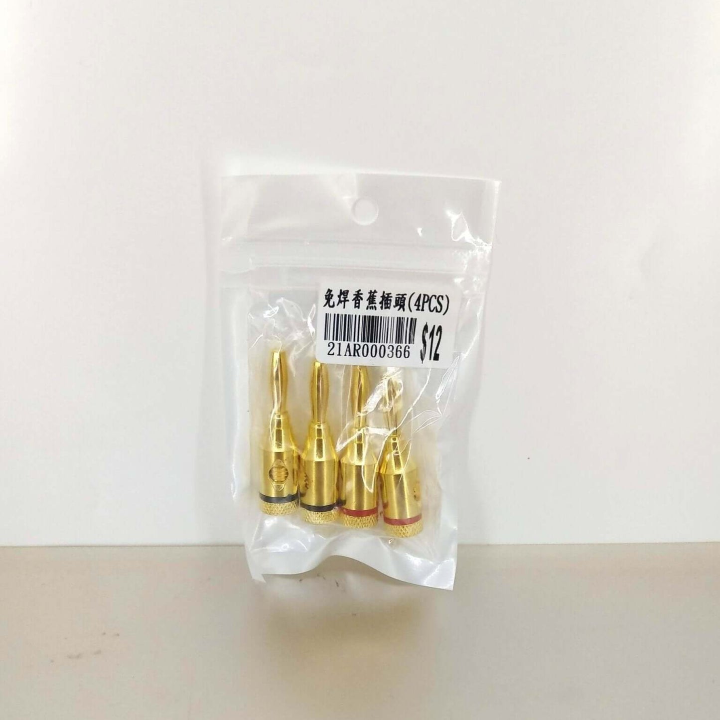 Gold-plated solderless speaker banana plugs in a sealed package, ideal for secure audio connections.