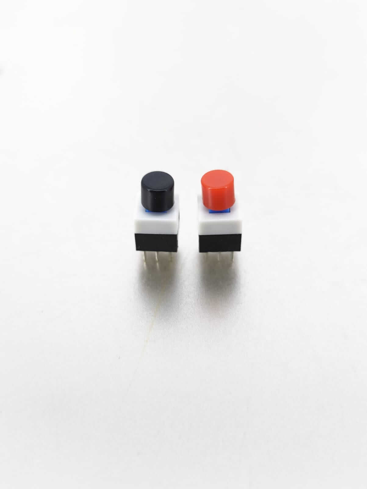 Two tactile mini push button switches with red and black caps, 8x8mm size, ideal for PCB layout in electronic devices.