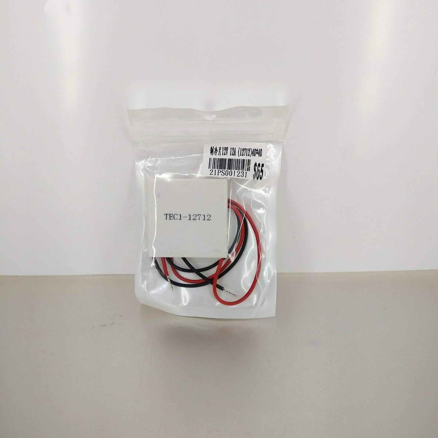 TEC1-12712 12V Thermoelectric Cooler Module shown in clear, protective packaging.