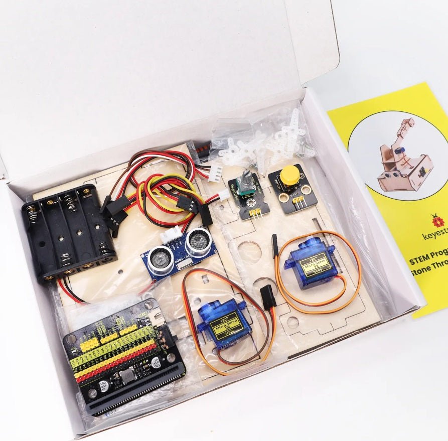 Keyestudio KS0807 micro:bit Thrower Learning Kit components in a box, featuring motors, sensors, and assembly materials.