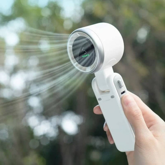 White handheld turbo fan operating outdoors, showing the strong airflow and high-speed operation.