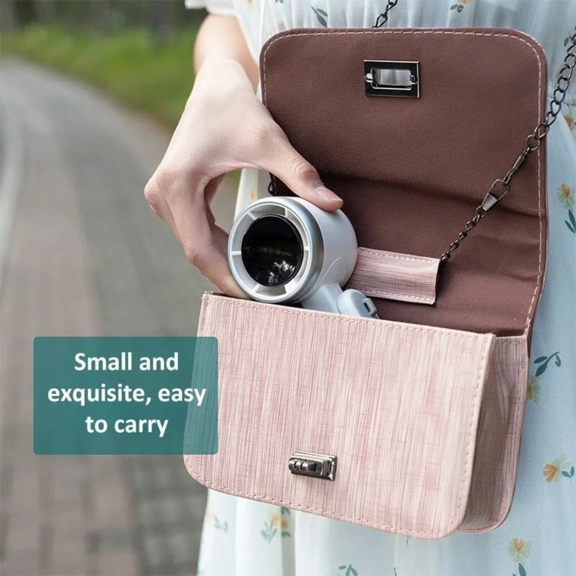 Small and exquisite white turbo fan being placed into a woman's shoulder bag, easy to carry.