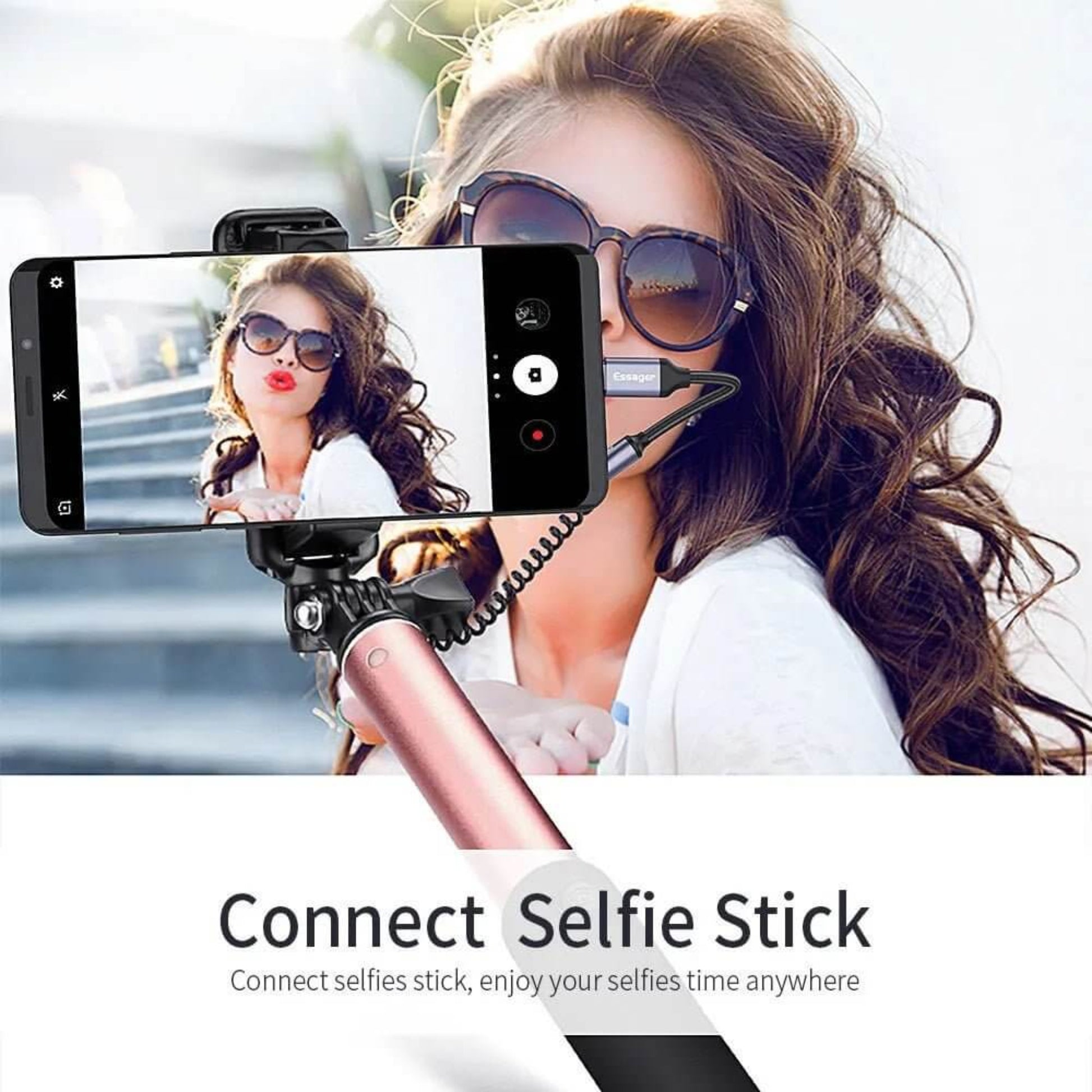 Woman using a selfie stick with a smartphone connected via the USB C to 3.5mm adapter.