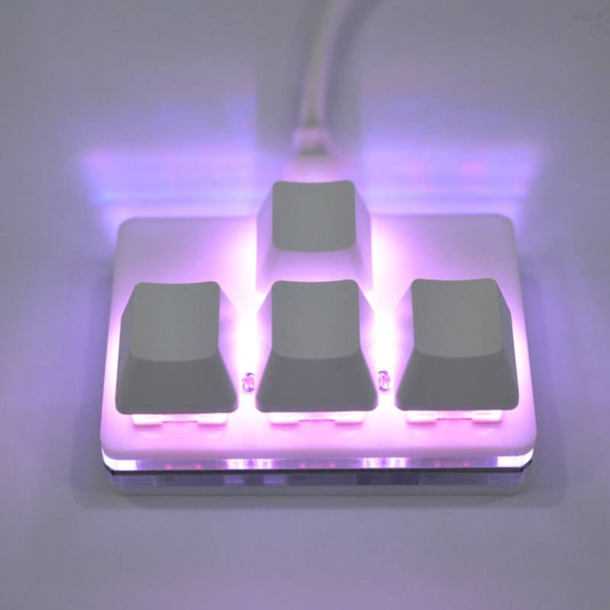 USB multifunctional mini keypad with illuminated keys for multimedia control and macro functions.