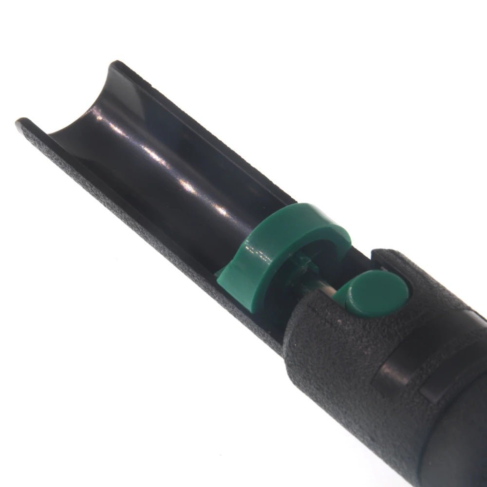 Close-up of a black plastic desoldering pump with a green button for solder removal.