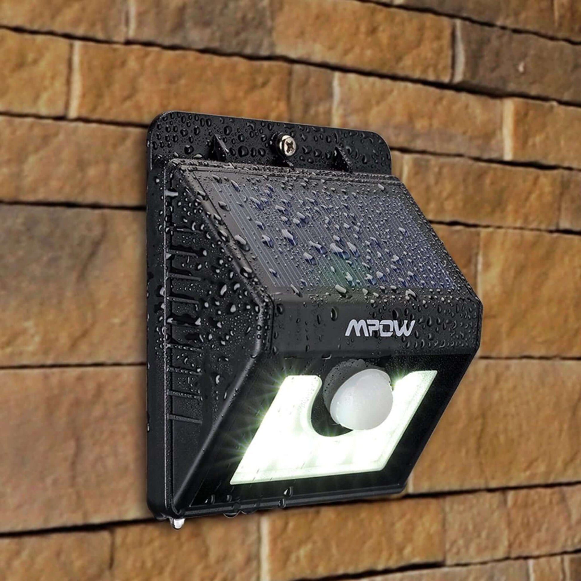 Mpow 8 LED Solar Motion Sensor Light with waterproof design mounted on stone wall.