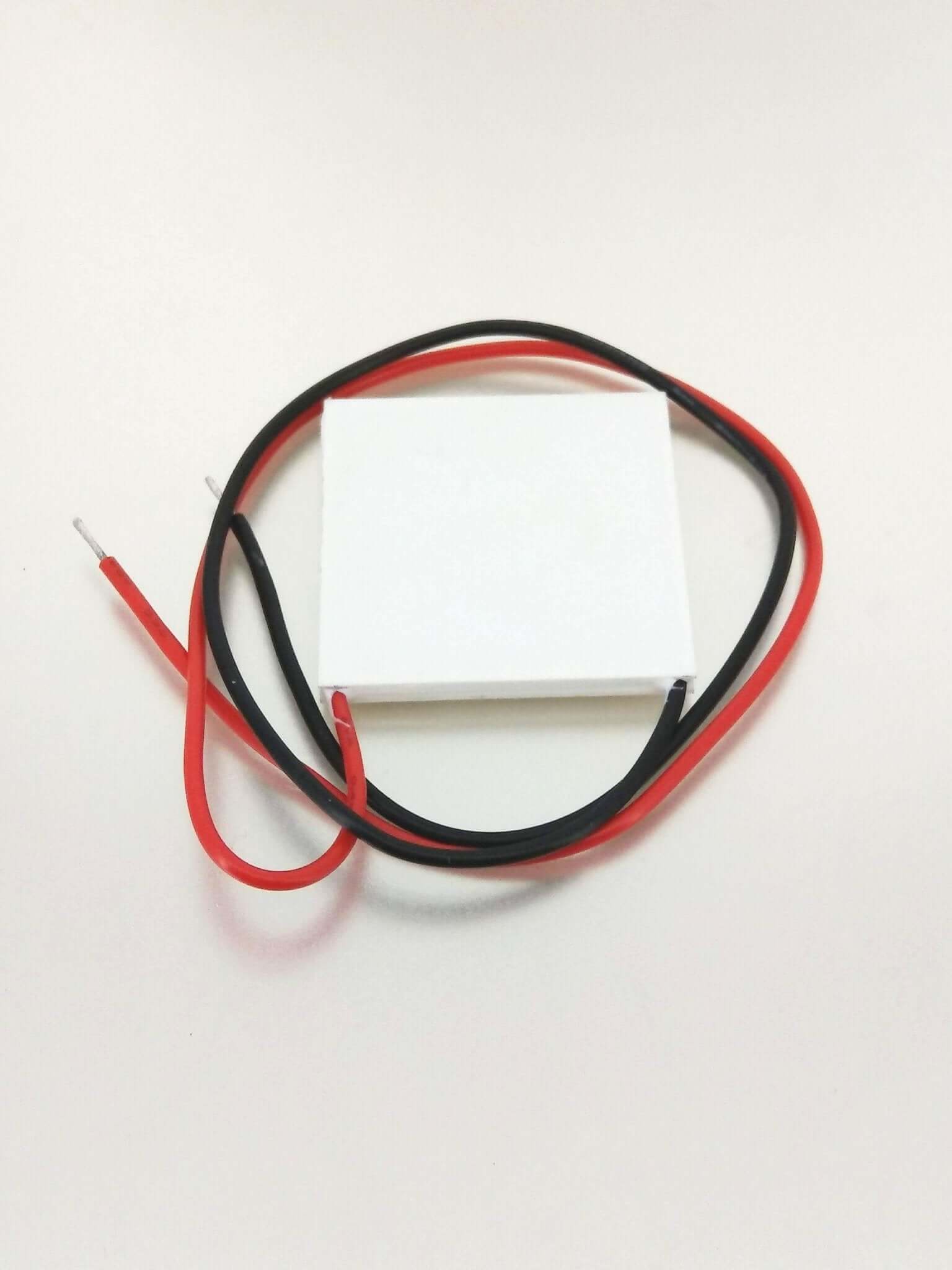 TEC1-12706 Peltier module with red and black wires for thermoelectric cooling or heating applications.