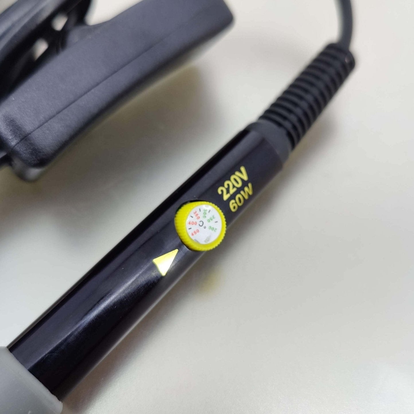 Close-up of a 60W adjustable temperature soldering iron with a 220V UK plug and temperature gauge.