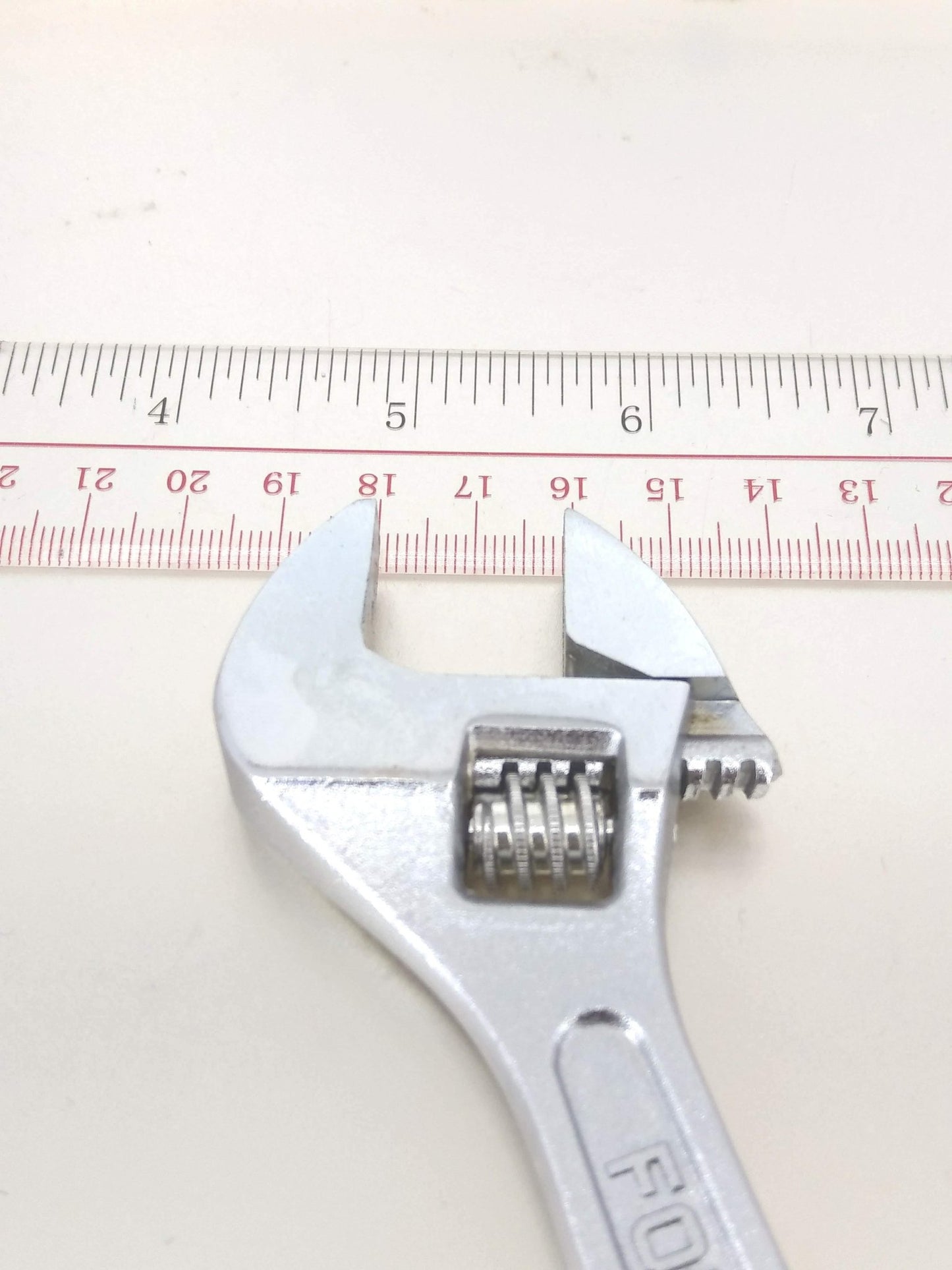 6-inch industrial grade carbon steel adjustable wrench with a measurement scale behind it for size reference.