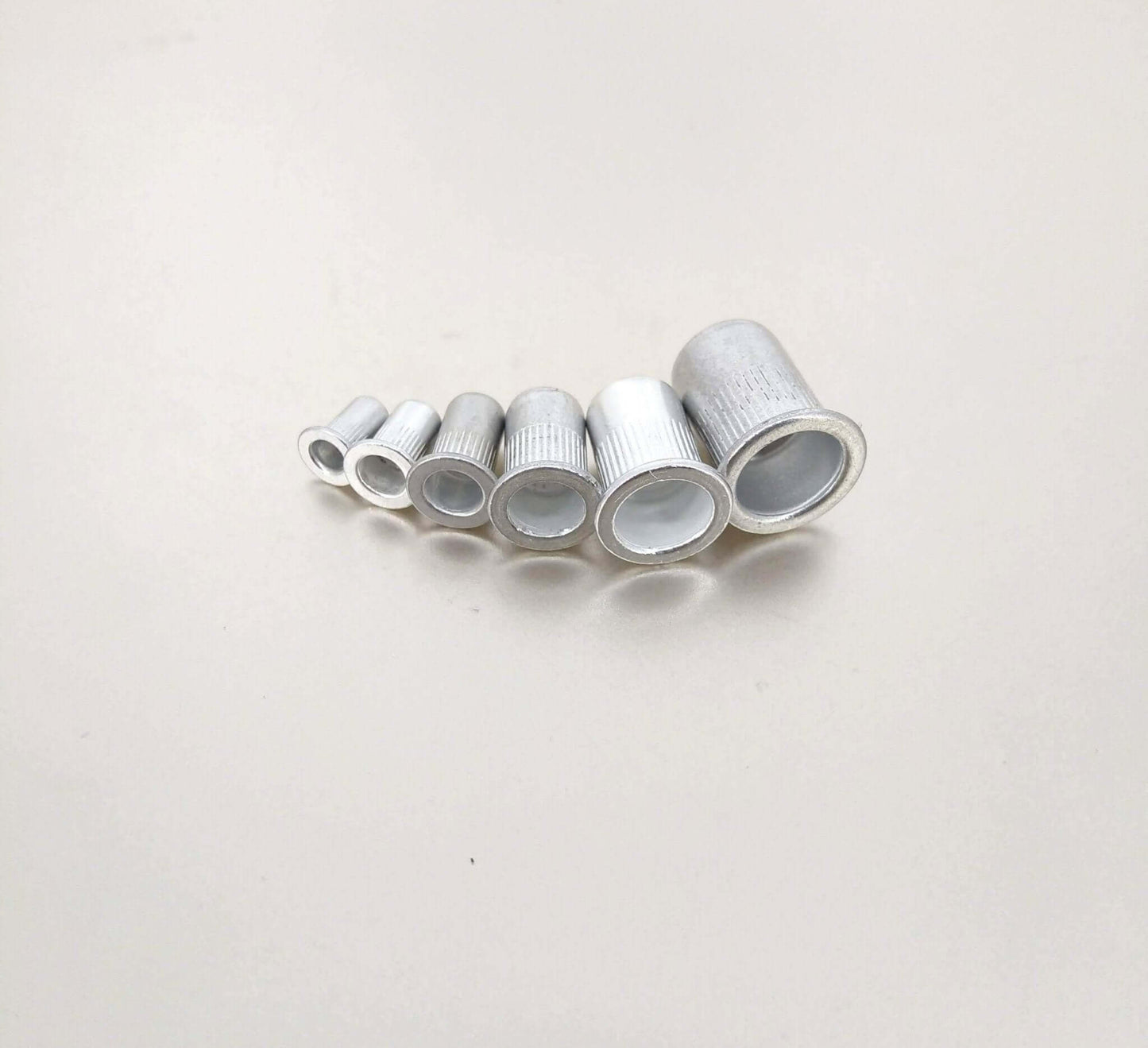Set of six aluminum rivet nuts in various sizes, ideal for creating strong threaded inserts in thin materials.