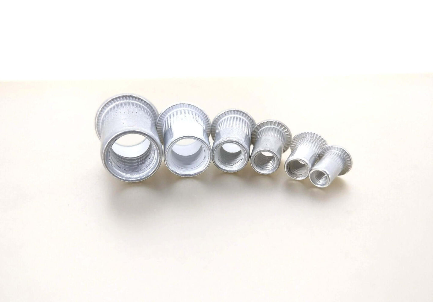 Assorted aluminum rivet nuts in various sizes, ideal for M3-M10 threaded insert applications.